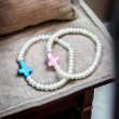 Pulsera perlas y cruz elástica 